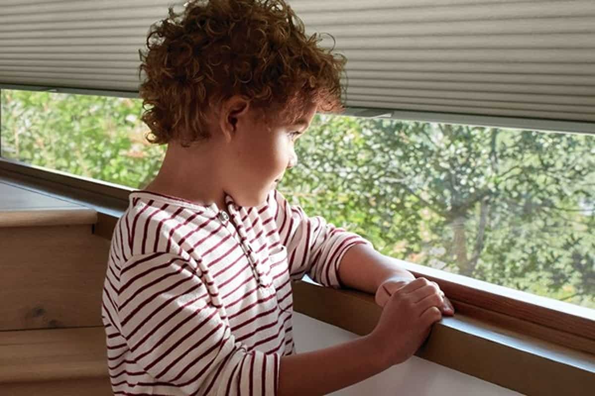 A child plays next to a window with a cordless window treatment near Westford, Massachusetts (MA)