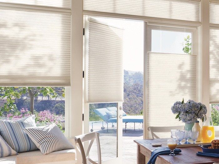 A dining room with view to the outside living space; both have blue accents.